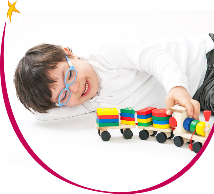 Criança com síndrome de down brincando com um trem